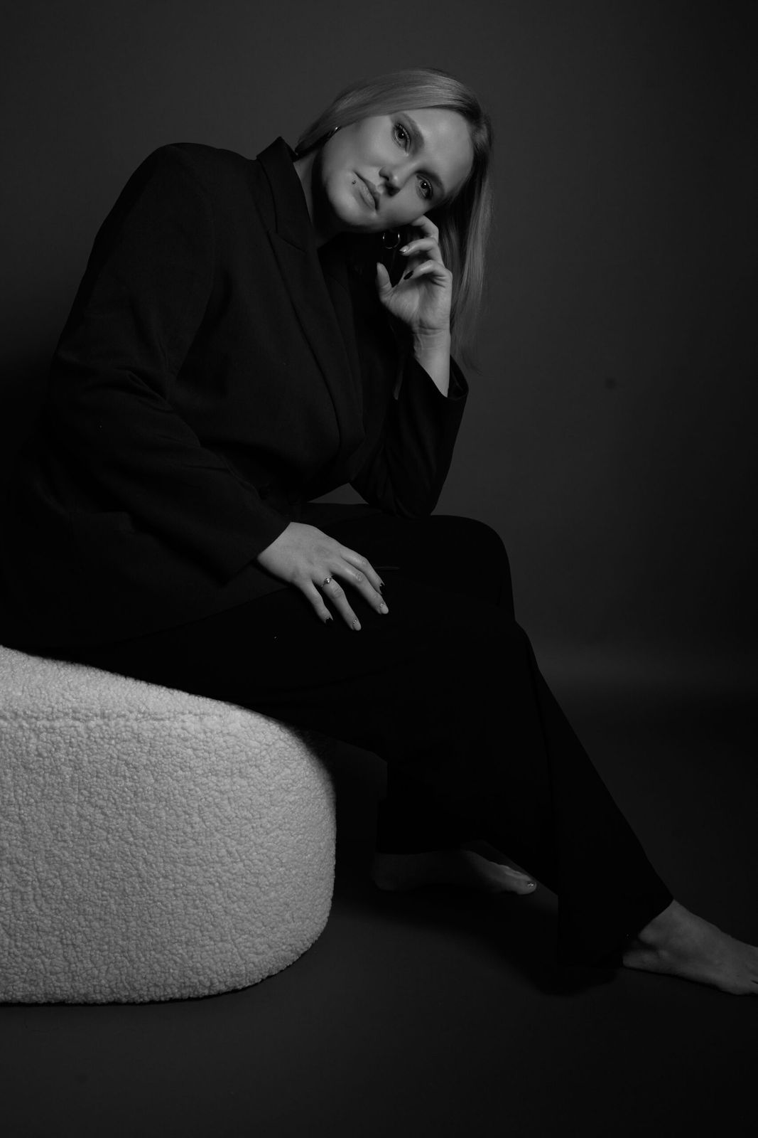 Dunkles Studioportrait einer Frau auf einem Polster