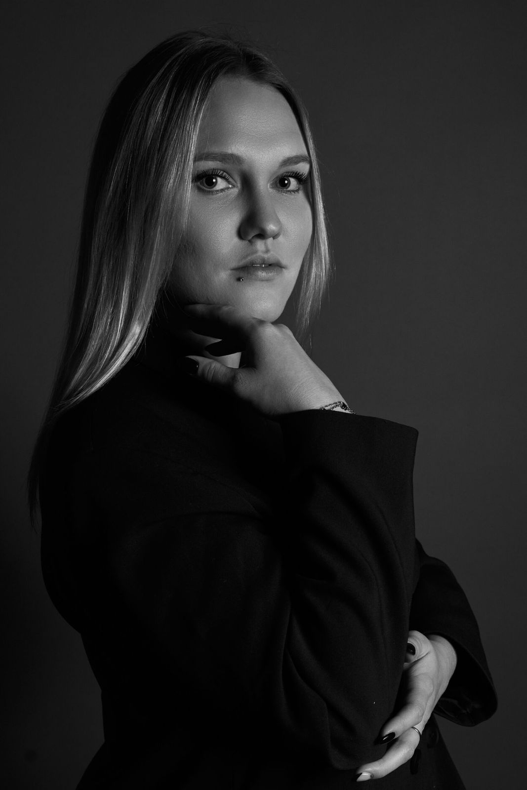 Ernstes Studioportrait einer jungen Frau in Schwarz